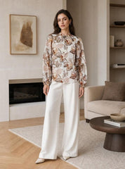 Yours Truly Floral Blouse in Beige - model wearing blouse with white wide-leg pants